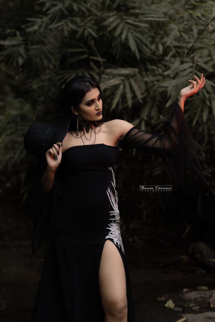 Model in a black gown posing among bamboo